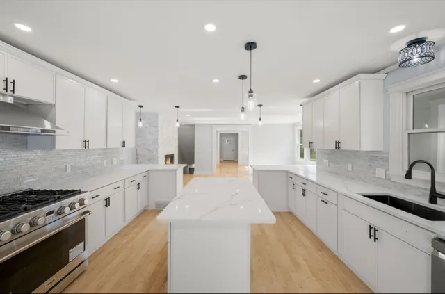 a large kitchen with stainless steel appliances granite countertop a lot of counter space and a sink