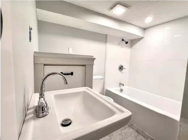 a bathroom with a tub sink and mirror