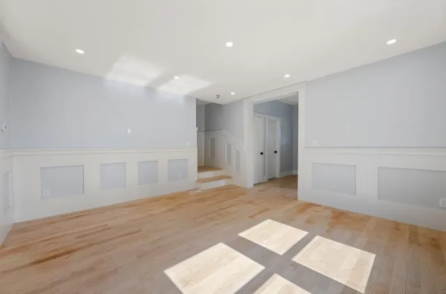 a view of an empty room with wooden floor