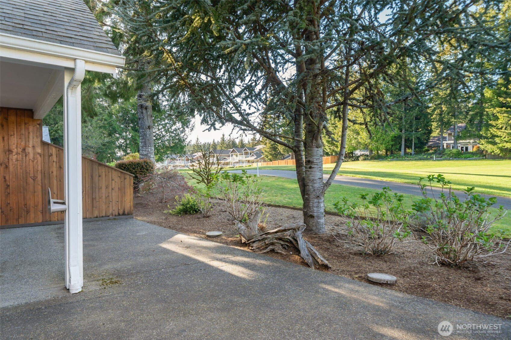 160 East Soderberg Road, Unit C7 Allyn, WA 98524 - Photo 32 of 39 a view of a yard with wooden fence and a large tree