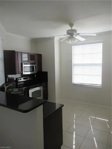 a kitchen with granite countertop a refrigerator and a stove top oven