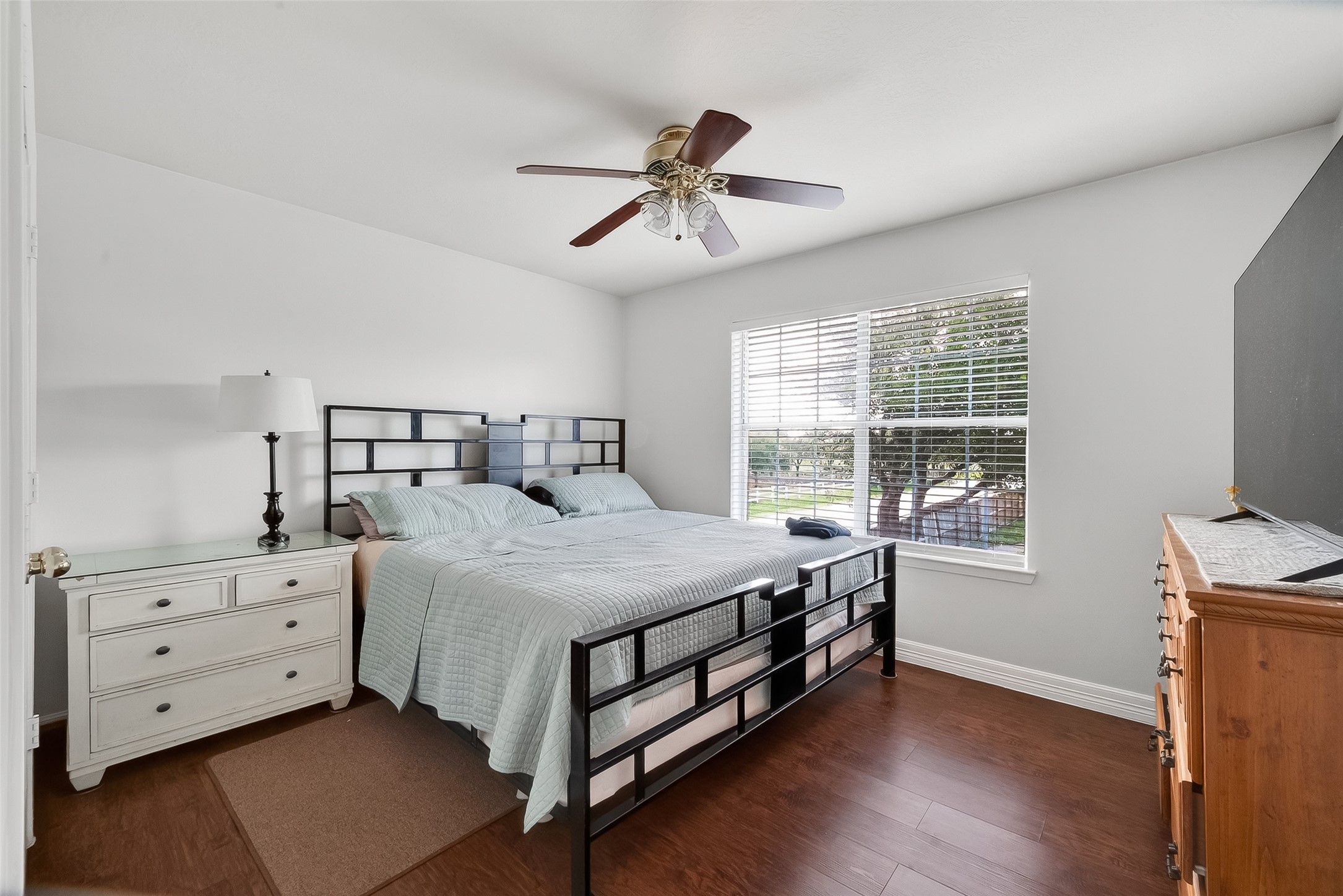 5902 Camron Point Circle Katy, TX 77449 - Photo 23 of 44 Secondary bedroom with hardwood floors, ceiling fan, and large windows providing natural light.