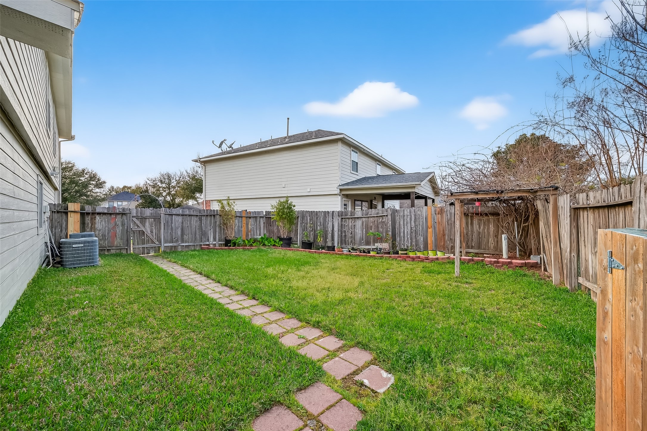 5902 Camron Point Circle Katy, TX 77449 - Photo 39 of 44 Fully fenced backyard with lawn space and pathway, ideal for outdoor activities.