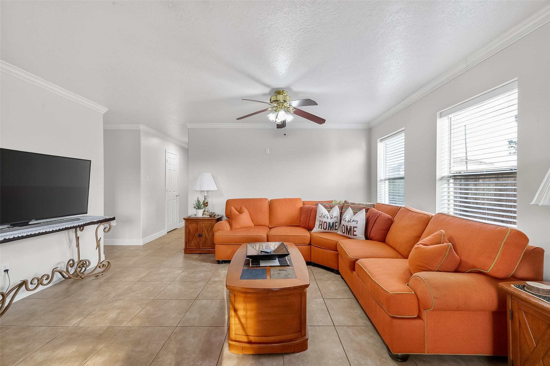 5902 Camron Point Circle Katy, TX 77449 - Photo 6 of 44 Bright and spacious living room featuring large windows, ceiling fan, and open layout ideal for entertaining.