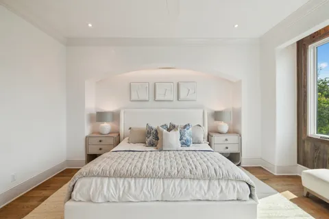 a bedroom with a bed and a large window