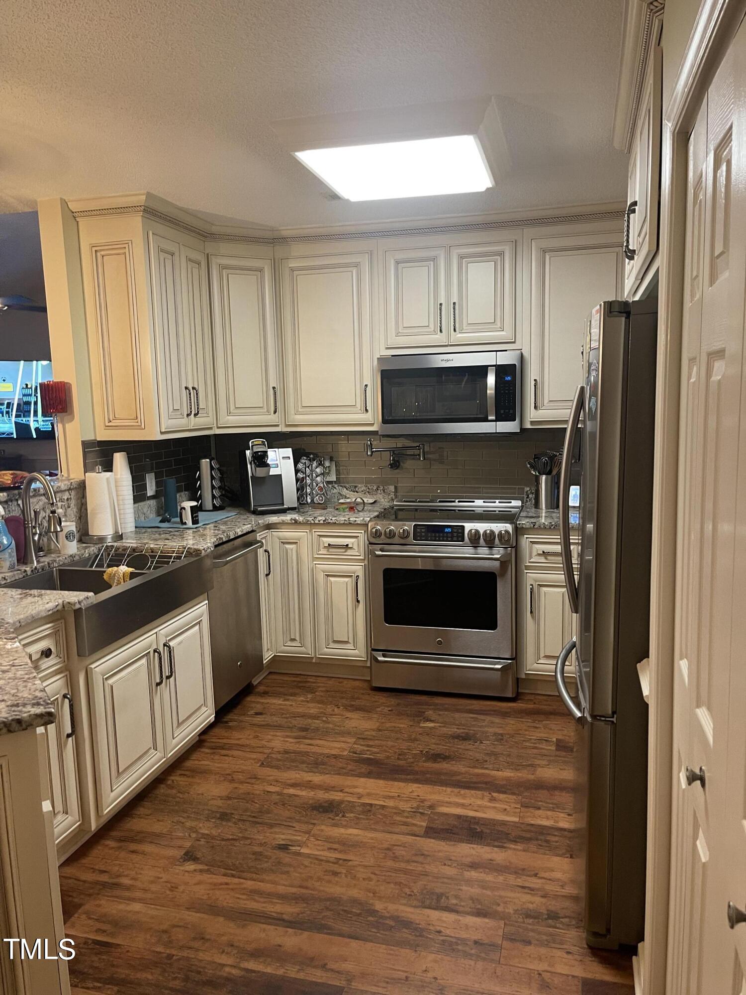 104 Chadbury Drive Dunn, NC 28334 - Photo 12 of 23 a kitchen with stainless steel appliances a stove a sink and a refrigerator