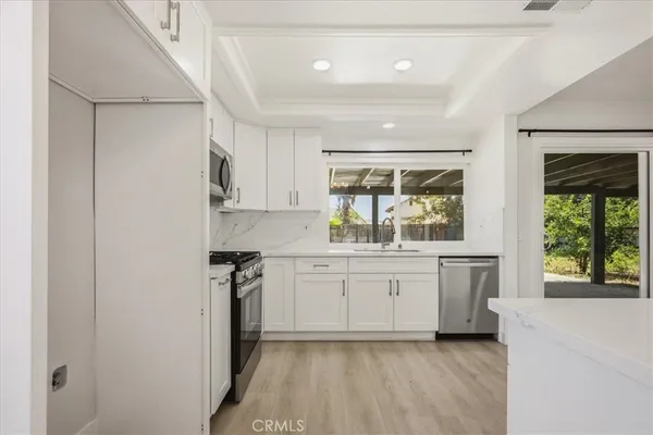 a kitchen with granite countertop white cabinets and white appliances