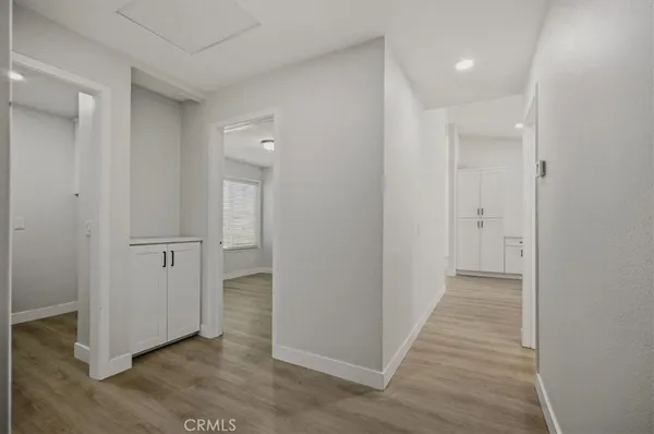 a view of a hallway with wooden floor and closet area