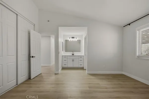 a view of a bedroom with cabinet mirror and windows