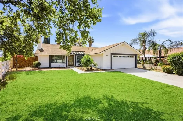 a front view of a house with yard and green space