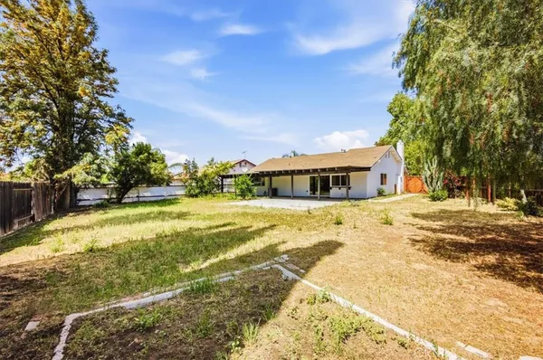 a yellow house with swimming pool in front of it