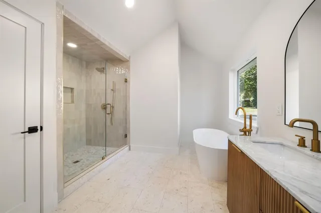 a bathroom with a granite countertop sink a mirror and a shower