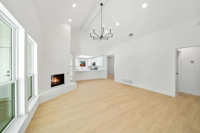 a view of an empty room with window and cabinet