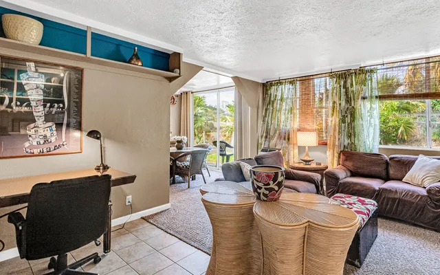 a living room with furniture and floor to ceiling windows