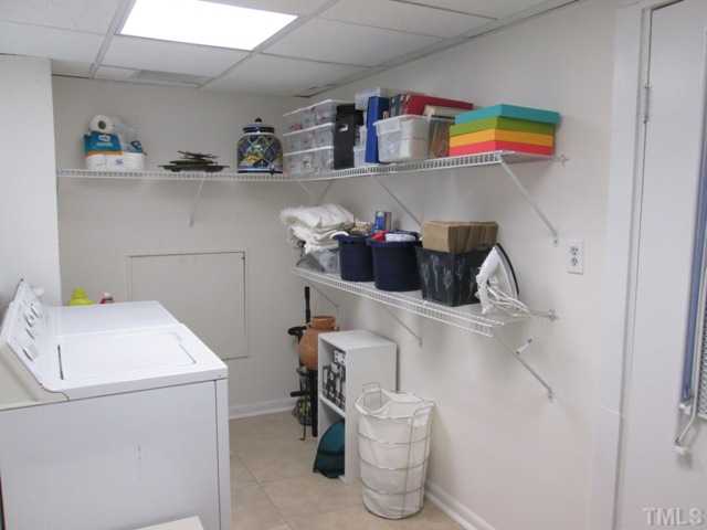 3409 Astro Court Raleigh, NC 27604 - Photo 25 of 25 The lower level laundry utility room features tile flooring, great shelving for extra storage space, and the crawl space access is located here! Whole house water shut off is right inside the crawl space access!