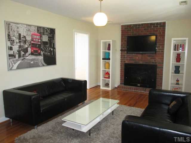 3409 Astro Court Raleigh, NC 27604 - Photo 9 of 25 The living room features a real masonry fireplace with a wood burning stove insert with blower, new light fixture, refinished hardwood floors in 2011, and a coat closet. Comfortable cozy living space that is nice and bright!