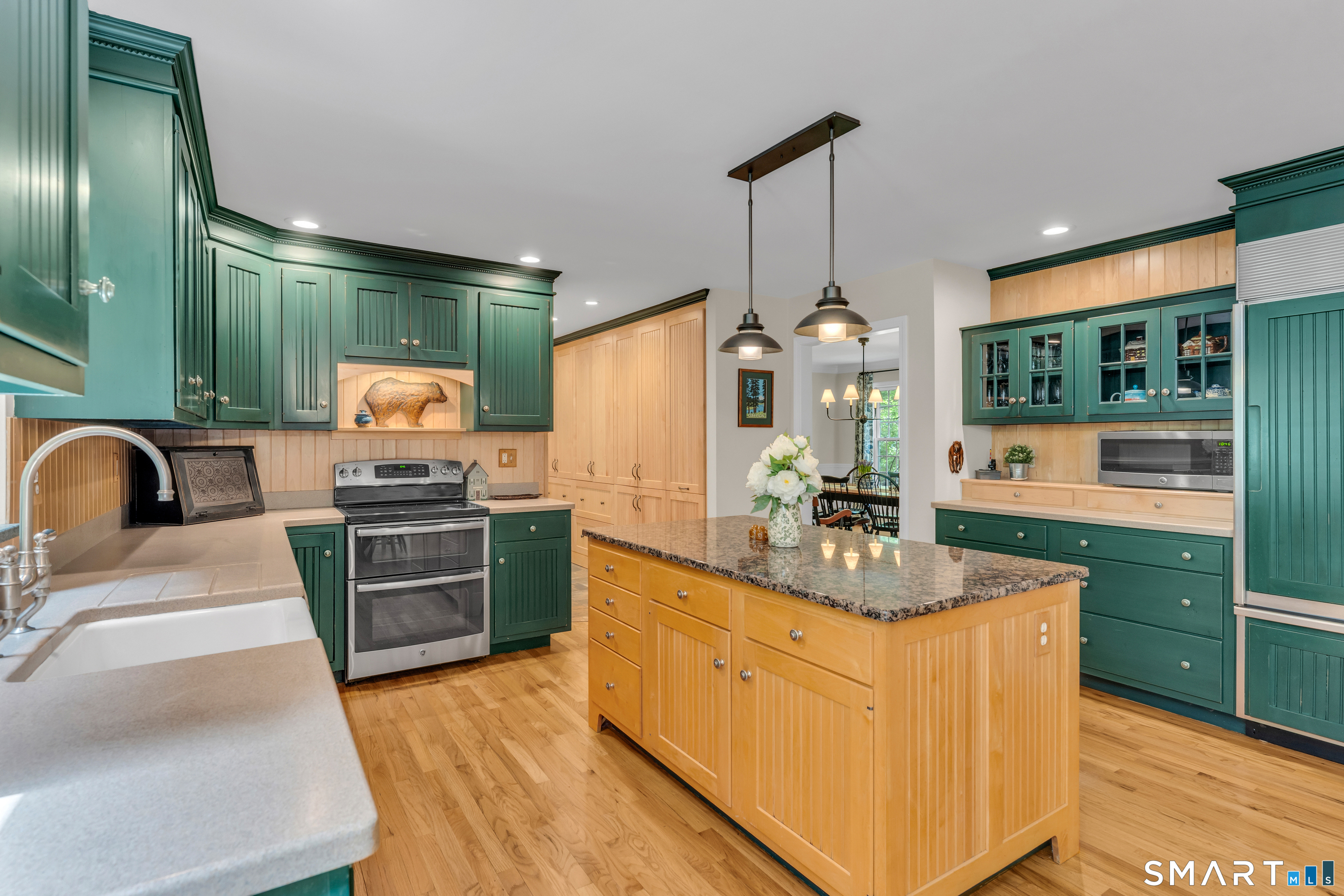46 Laurel Cliffs Road Guilford, CT 06437 - Photo 8 of 40 The Kitchen with a granite topped center island and abundant storage is fresh and easy to navigate. Notice the great storage in the hall that leads to the Garage.
