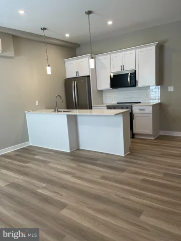 a view of kitchen with stainless steel appliances granite countertop refrigerator oven a sink dishwasher and a stove with wooden floor