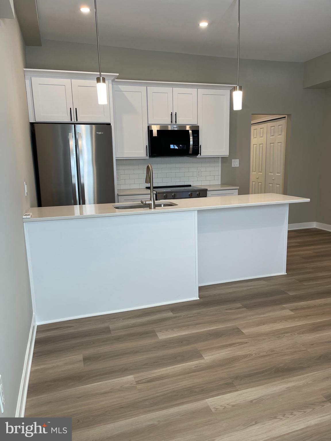 189 Bridge Street, Unit 2 Phoenixville, PA 19460 - Photo 2 of 10 a view of kitchen with stainless steel appliances granite countertop cabinets and wooden floor