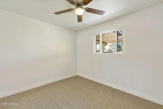 an empty room with closet and a chandelier fan