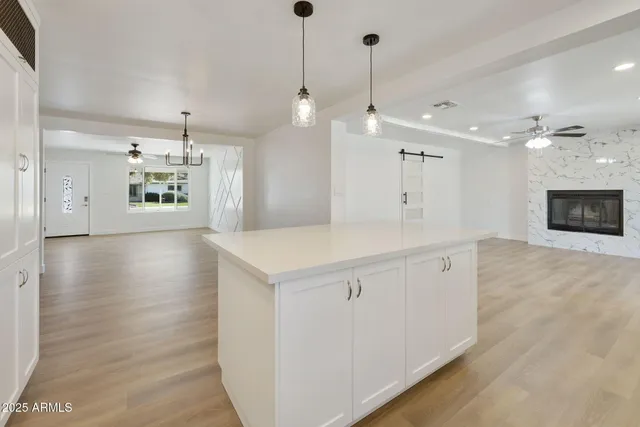 a large kitchen with kitchen island a sink stainless steel appliances and white cabinets