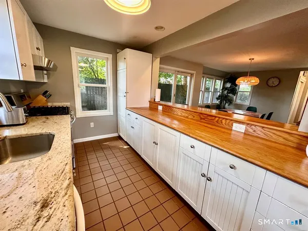a large white kitchen with stainless steel appliances granite countertop a sink and cabinets
