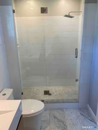 a bathroom with a shower a toilet and a sink