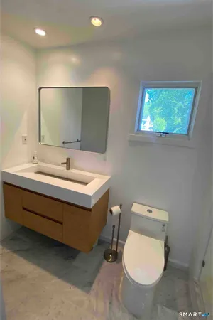 a bathroom with a toilet sink and mirror