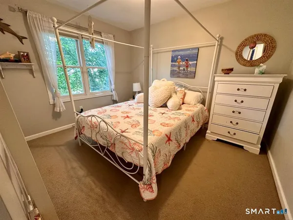 a bed sitting in a bedroom next to a window