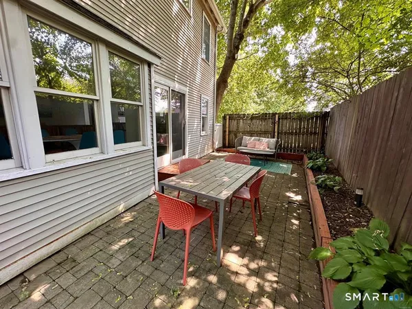 a backyard of a house with table and chairs
