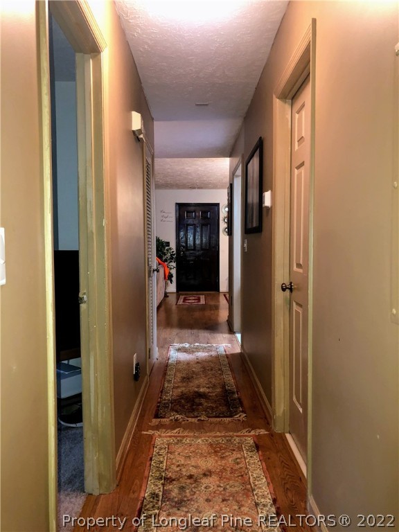 1828 Sardonyx Road, Unit 3 Fayetteville, NC 28303 - Photo 19 of 22 a view of a hallway with wooden floor and a bathroom