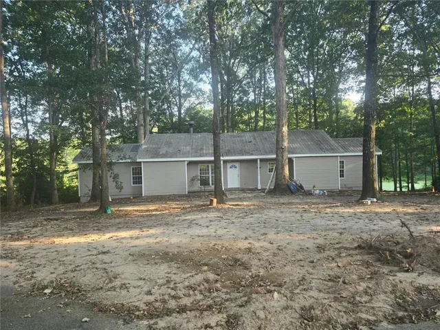 a view of a house with a yard and large tree