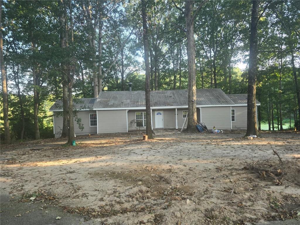 a view of a house with a yard and large tree