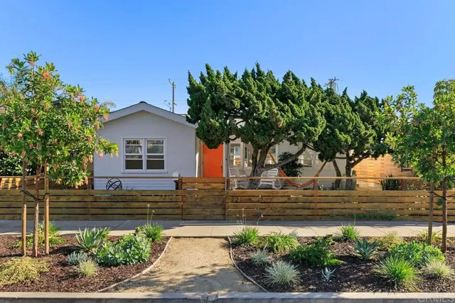 a front view of a house with a garden