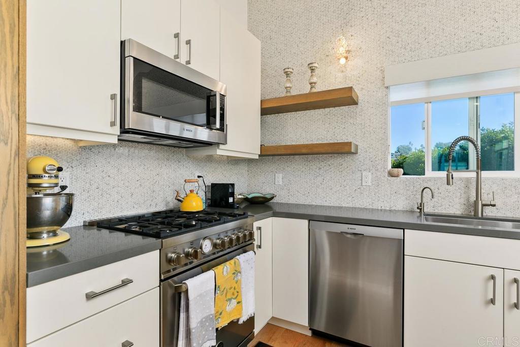 721 3rd Street Encinitas, CA 92024 - Photo 28 of 36 a kitchen with stainless steel appliances granite countertop a sink stove and microwave
