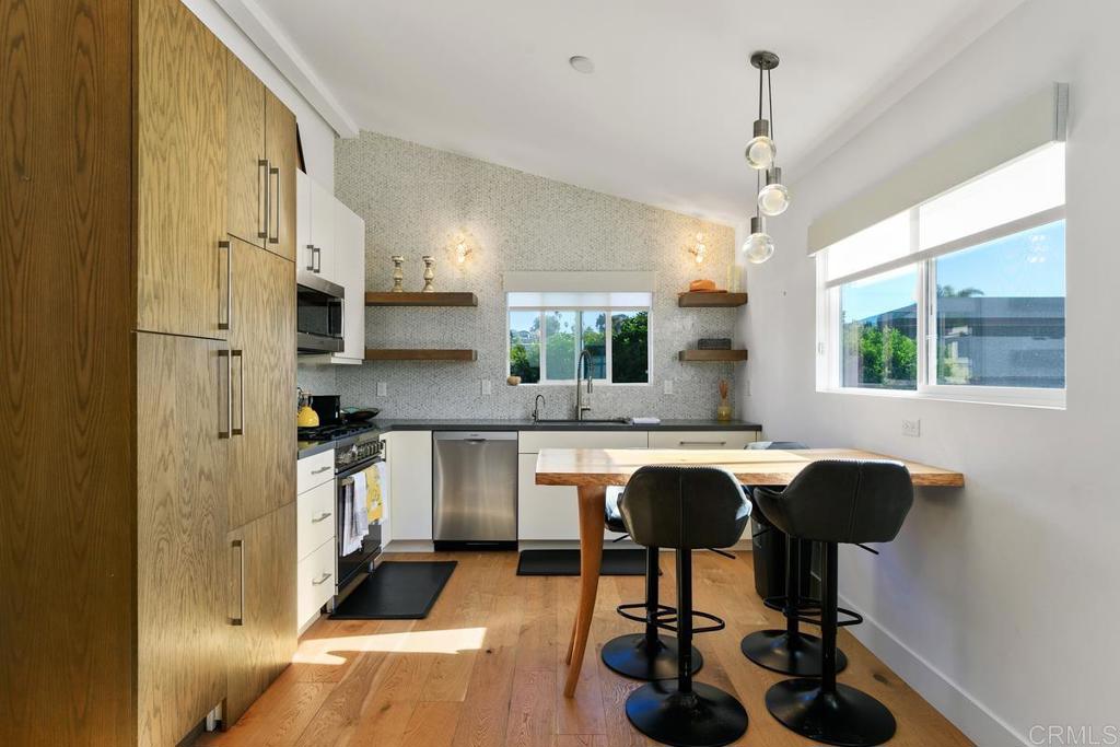 721 3rd Street Encinitas, CA 92024 - Photo 30 of 36 a kitchen with stainless steel appliances granite countertop sink cabinets and wooden floor