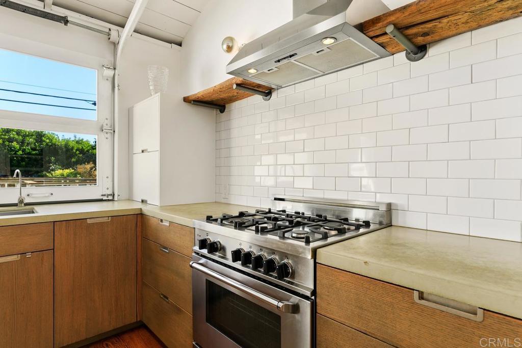 721 3rd Street Encinitas, CA 92024 - Photo 10 of 36 a kitchen with a stove a window cabinets and a counter top space