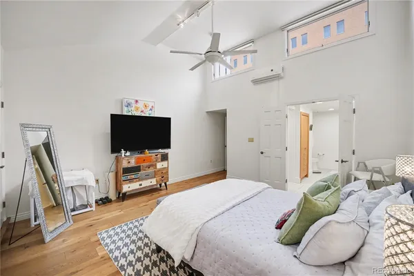 a bedroom with a bed a flat screen tv and a couch