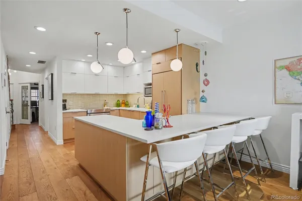 a view of a dining room and livingroom with furniture wooden floor a chandelier