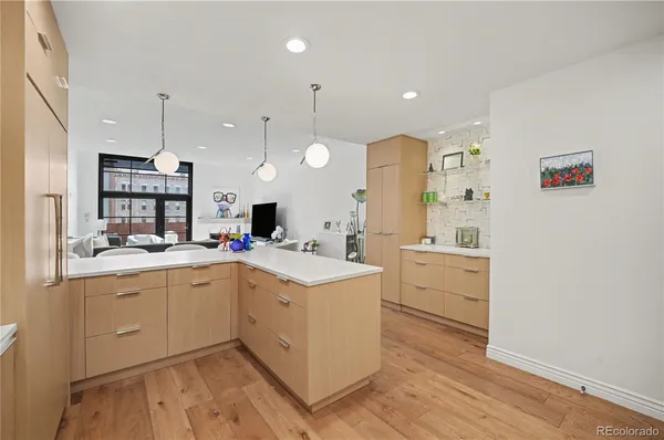 a large kitchen with a lot of counter space and wooden floor