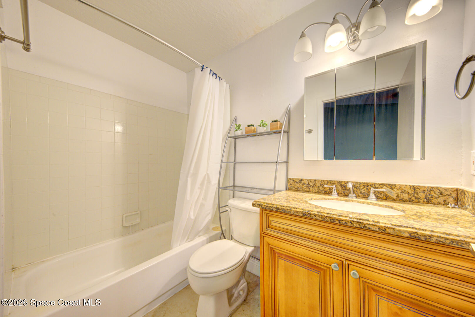 7667 North Wickham Road, Unit 1416 Melbourne, FL 32940 - Photo 12 of 41 a bathroom with a sink toilet a mirror and bathtub