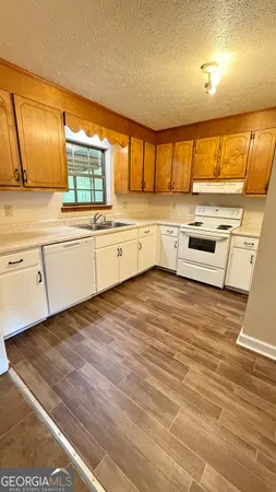 a kitchen with stainless steel appliances granite countertop a sink window and cabinets