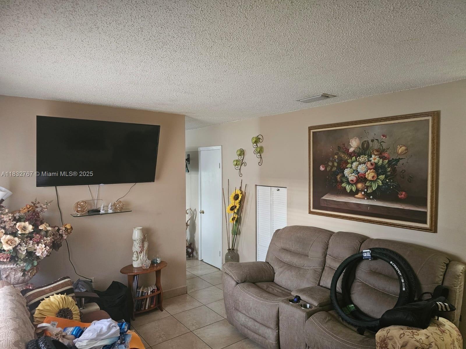 1521 West 42nd Place, Unit 18 Hialeah, FL 33012 - Photo 14 of 14 a living room with furniture and a flat screen tv