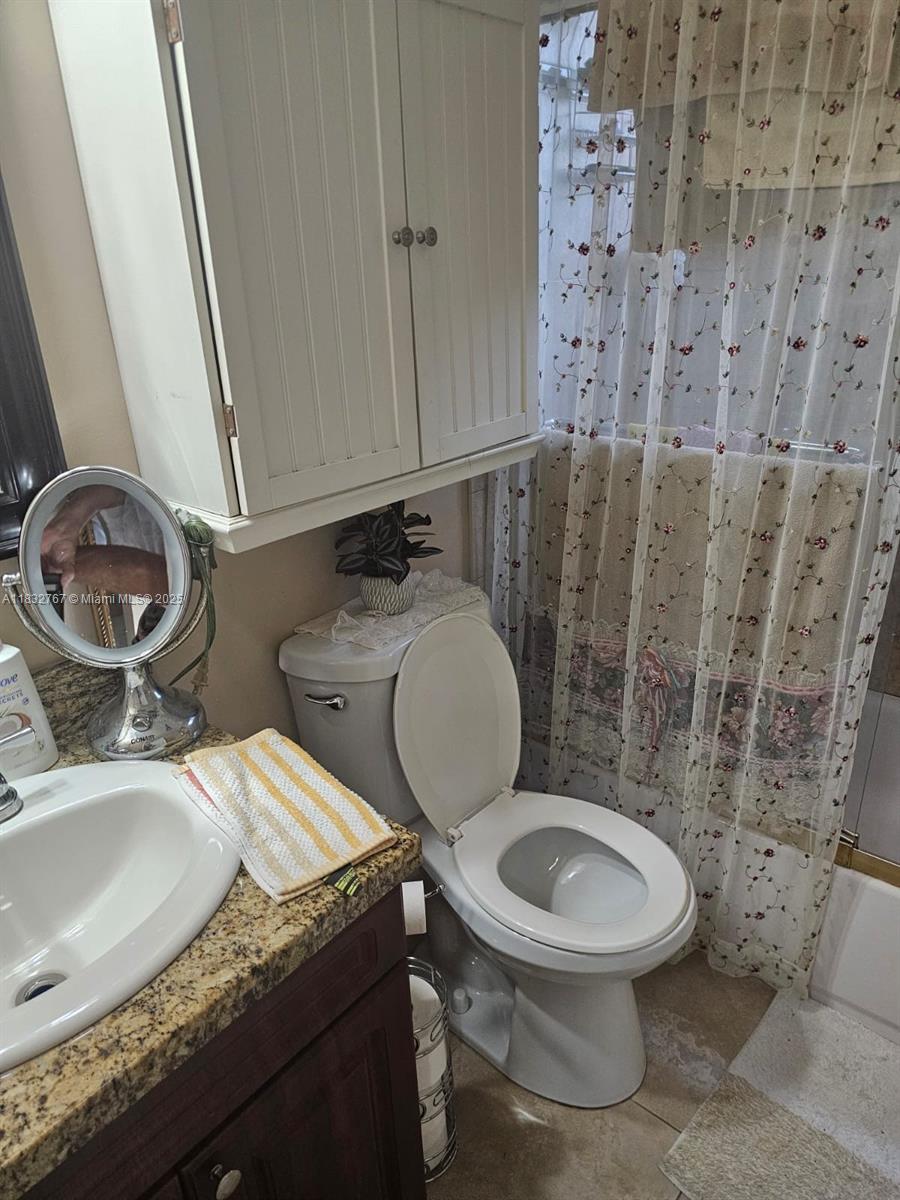 1521 West 42nd Place, Unit 18 Hialeah, FL 33012 - Photo 8 of 14 a bathroom with a granite countertop toilet sink and mirror