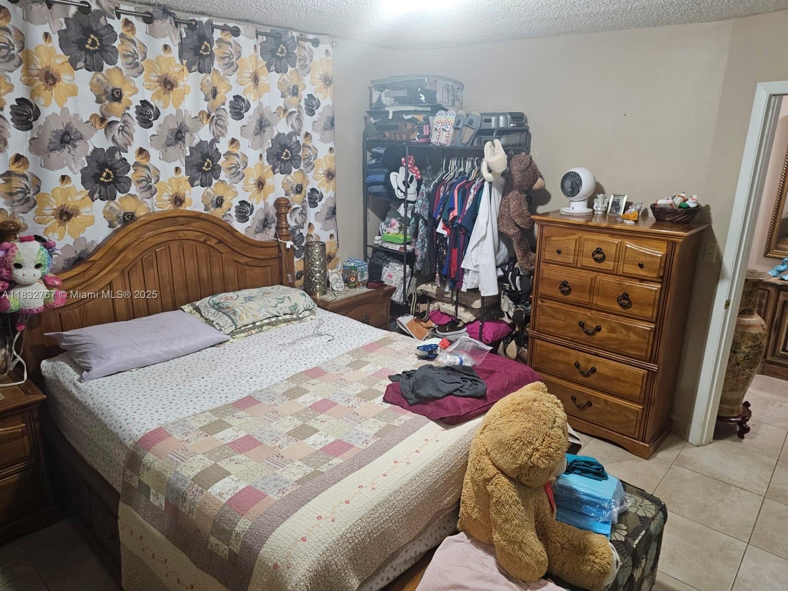 1521 West 42nd Place, Unit 18 Hialeah, FL 33012 - Photo 9 of 14 a bed sitting in a bedroom and dresser with rug