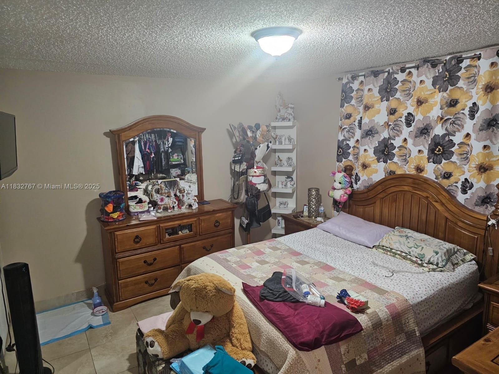 1521 West 42nd Place, Unit 18 Hialeah, FL 33012 - Photo 10 of 14 a bed room with a bed and a dresser