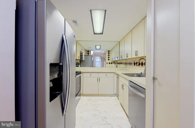 a kitchen with white cabinets and refrigerator