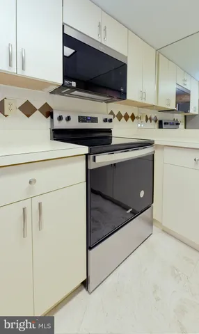 a kitchen with stainless steel appliances a stove a microwave and a sink