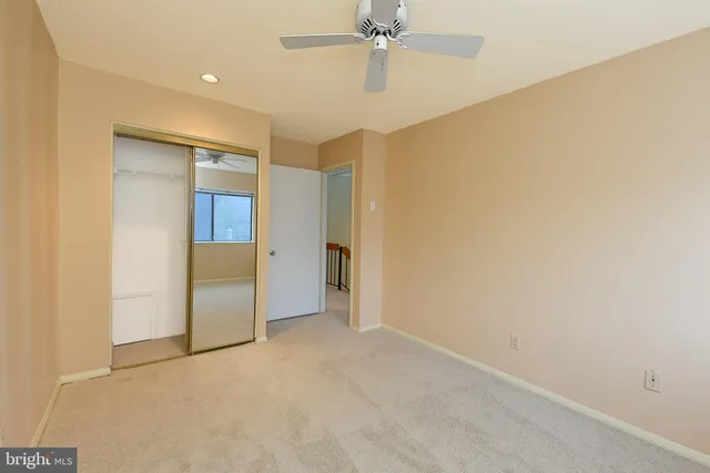 an empty room with closet and a chandelier fan