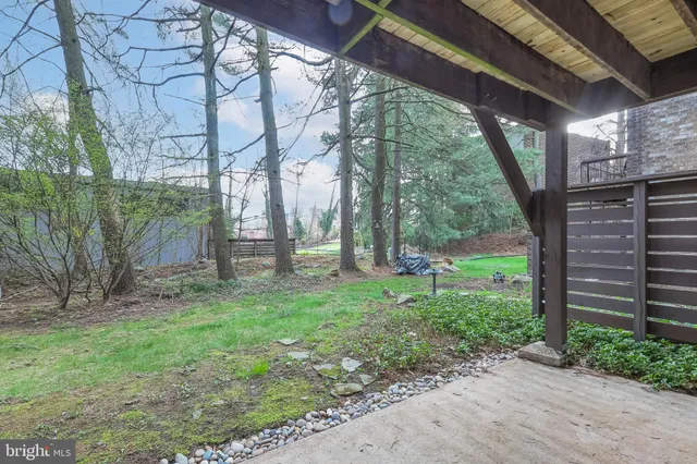 a backyard of a house with plants and large trees